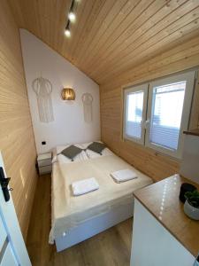 a small bedroom with a bed in a wooden room at Domki Przy Brzegu Chłapowo in Władysławowo