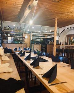 Almberghütte في فيليبسغويت: غرفة طعام مع طاولة طويلة مع مناديل سوداء