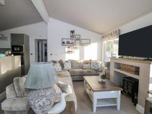a living room with a couch and a tv at Amberwood 42 in Lymington