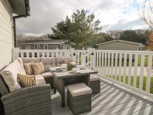 a patio with a couch and a table on a deck at Amberwood 42 in Lymington