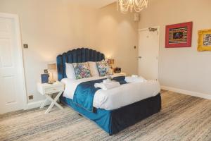 una camera con un grande letto con testiera blu di The Royal Kings Arms a Lancaster