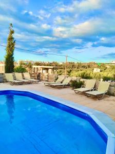 una piscina con tumbonas en un patio en Thalasinos Luxury Villa, en Gournes