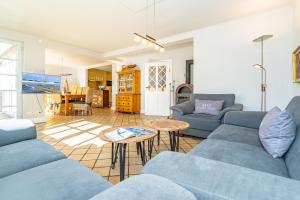 uma sala de estar com sofás azuis e uma mesa em Landhaus Nici em Westerland