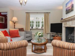 a living room with a couch and a fireplace at Early Mist Cottage in Newton Abbot