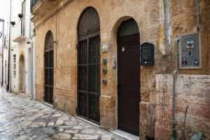 an alley with black doors on a stone building at Bed & Breakfast Mare Nostrum in Brindisi