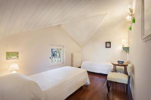 1 Schlafzimmer mit 2 Betten und einem Tisch mit einem Stuhl in der Unterkunft Casa Del Custode in the heart of Valpolicella in San Pietro in Cariano