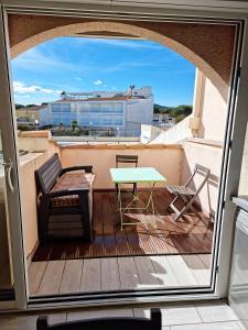 uma vista para uma varanda com uma mesa e cadeiras em Studios Village Naturiste Port Venus Enigma & Studio Port Soleil Orchidée em Cap d'Agde