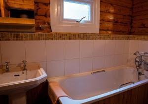een badkamer met een bad en een wastafel bij Scalpay Lodge in Duirinish