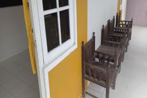 eine Gruppe Stühle in einem Zimmer mit Fenster in der Unterkunft SPOT ON 92390 Wilma Kost Syariah in Banjarmasin