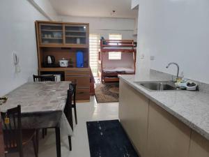 a kitchen with a sink and a table with chairs at Mines View - nice studio good for 2-8 persons! in Baguio