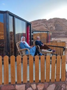 a man and a woman sitting in chairs on a house at Bedouin Holidays Camp and Jeep Tours in Wadi Rum