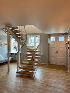a spiral staircase in a living room with a door at VISIONHOUSE Hotel in Frederikssund