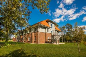 an exterior view of a house with an orange roof at Hössensportzentrum in Westerstede