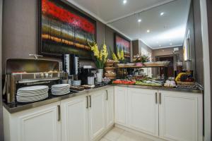 a kitchen with white cabinets and plates on a counter at Hotel 19 Batumi in Batumi