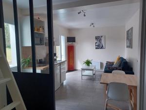cocina y sala de estar con sofá y mesa en Appartement Havre de paix Landais en Saint-Barthélemy