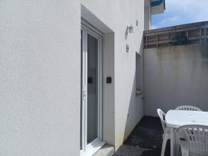 una puerta a un patio con mesa y sillas en Appartement Havre de paix Landais en Saint-Barthélemy
