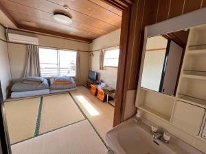 a bathroom with a sink and a bed in a room at HOSTEL OE in Yoshinogawa