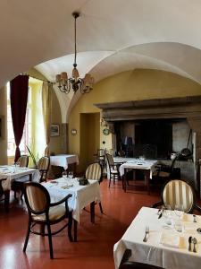 a dining room with tables and chairs and a fireplace at Hôtel Restaurant Chez Gervais in Quingey