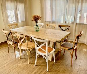 una mesa de madera con sillas y un jarrón de flores. en Casa Rural El Rincón de Beatriz, en Ayódar