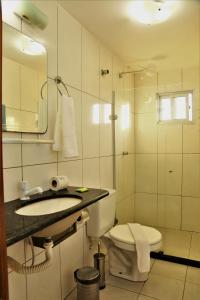 y baño con aseo, lavabo y ducha. en Beleza Tropical Pousada Hotel en Fortaleza
