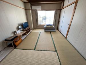 a small room with a bed and a window at HOSTEL OE in Yoshinogawa