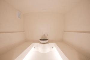 a white room with a toilet in the middle at Erato by Samian Mare in Karlovasi