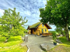een klein geel huis met een grasdak bij Sarpsborg Apartments - Utne Camping in Solli