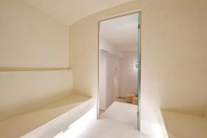 a glass door in a white room with a mirror at Erato by Samian Mare in Karlovasi