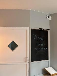 een schoolbord naast een deur met een bord erop bij VISIONHOUSE Hotel in Frederikssund