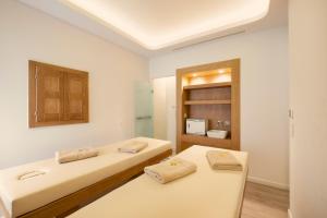 two beds in a room with a bathroom at Erato by Samian Mare in Karlovasi