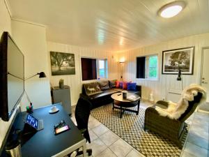 een woonkamer met een bank en een tafel bij Sarpsborg Apartments - Utne Camping in Solli