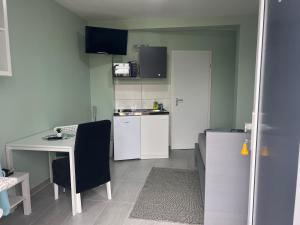 a small kitchen with a desk and a table at Ullis Pension für Monteure & Handwerker in Malsch