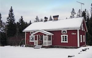 a red house with snow on top of it at Nice Home In Strömsnäsbruk With Kitchen in Sånnamad