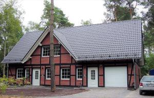 une maison en briques rouges avec un garage blanc dans l'établissement Apartment-Sonnenparadies-Wandlitz, à Wandlitz