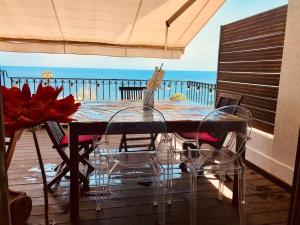 uma mesa e cadeiras num deque com vista para o oceano em Magnifique triplex face à la Mer em San-Martino-di-Lota