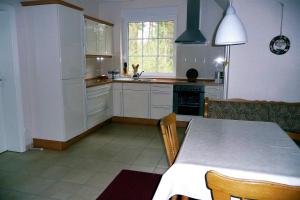 una cocina con armarios blancos y una mesa con sillas. en Apartment-Sonnenparadies-Wandlitz en Wandlitz
