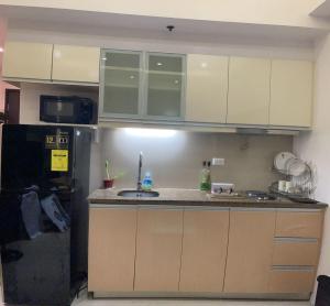 La cuisine est équipée d'un évier et d'un réfrigérateur. dans l'établissement EJ's Staycation 22nd F with 200mbps Wi-Fi and NETFLIX, à Manille