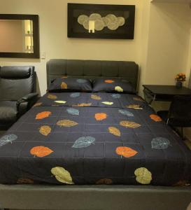 - un lit avec une couette dans une chambre dans l'établissement EJ's Staycation 22nd F with 200mbps Wi-Fi and NETFLIX, à Manille