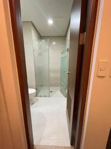 La salle de bains est pourvue d'une douche et de toilettes. dans l'établissement EJ's Staycation 22nd F with 200mbps Wi-Fi and NETFLIX, à Manille