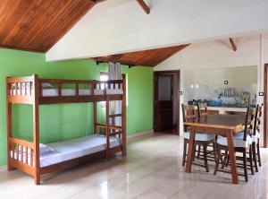 a room with bunk beds and a table and a kitchen at hotel trecicogne in Morondava