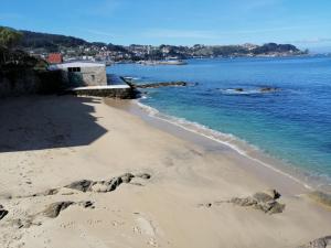 a beach with rocks in the sand and the water w obiekcie Ático de Ana w mieście Bueu