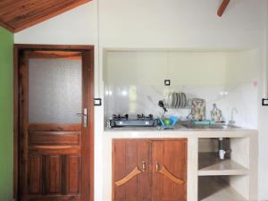a kitchen with a sink and a wooden door at hotel trecicogne in Morondava