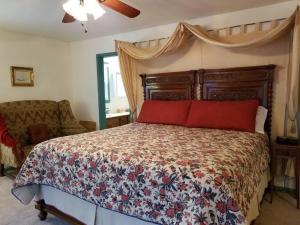a bedroom with a bed with red pillows at Aldrich House Bed & Breakfast in Williamsburg