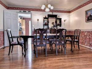 a dining room with a black table and chairs at Aldrich House Bed & Breakfast in Williamsburg