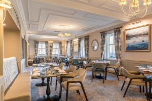 a restaurant with tables and chairs and a chandelier at The Borrowdale Hotel in Keswick