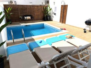 una piscina con sillas, una mesa y una piscina en Nerja Paradise Rentals - Villa Topaz, en Nerja