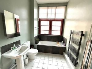 a bathroom with a tub and a toilet and a sink at Charming 2 Bed Apartment in Centre of Nottingham in Nottingham