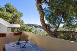 a table with glasses on a fence with a tree at Bouganville in Leuca