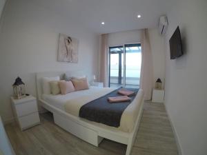 a bedroom with a bed with a view of the ocean at Beach Apt Bica-AC/Heating+Terraces & Pool-3 bdr in Ferrel