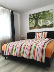 a bedroom with a bed with a striped comforter at Hotel Alt-Holzhausen in Bad Pyrmont